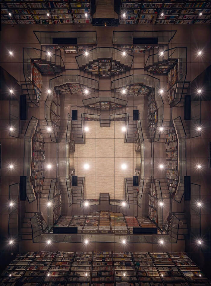 M.C. Escher Woodcut Inspired Bookstore With Mirrored Ceiling and Criss-Crossed Stairwells