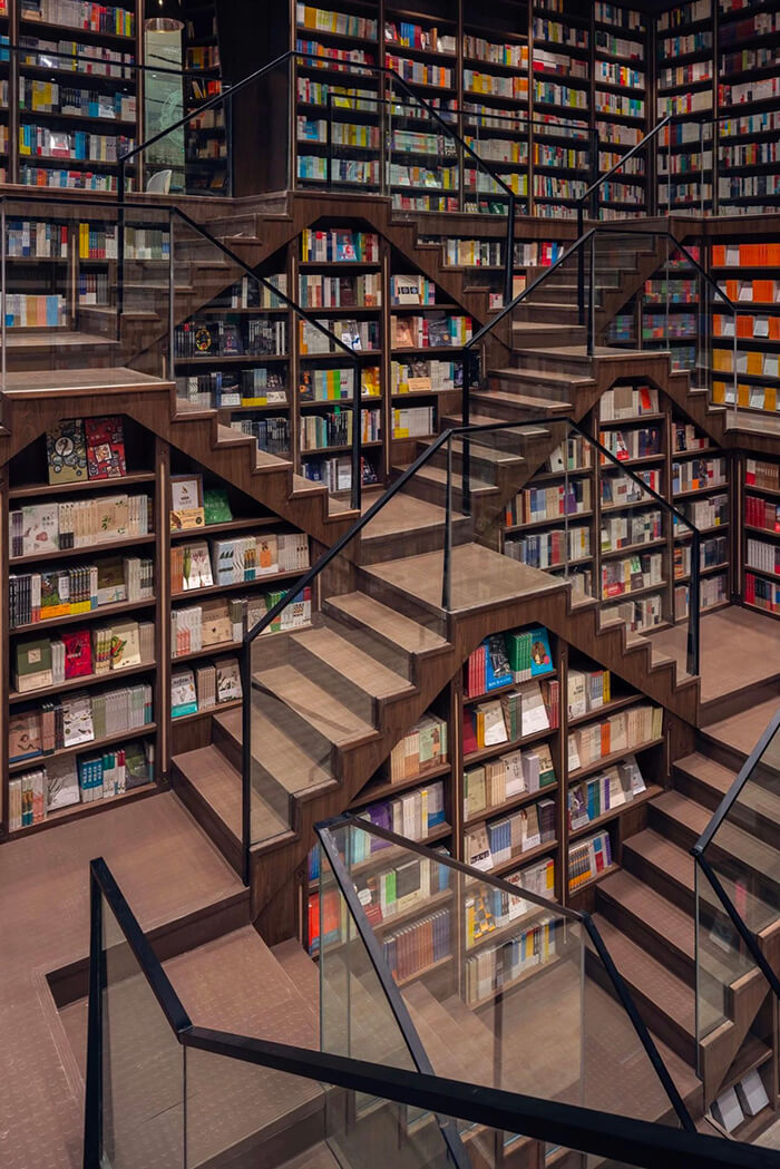 M.C. Escher Woodcut Inspired Bookstore With Mirrored Ceiling and Criss-Crossed Stairwells