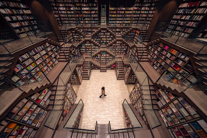 M.C. Escher Woodcut Inspired Bookstore With Mirrored Ceiling and Criss-Crossed Stairwells